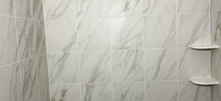 Marble tiles used as a bathtub surround walls with corner bath shelves